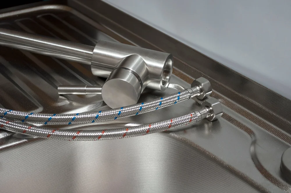 Braided flexi hoses with blue and red markings on a sink