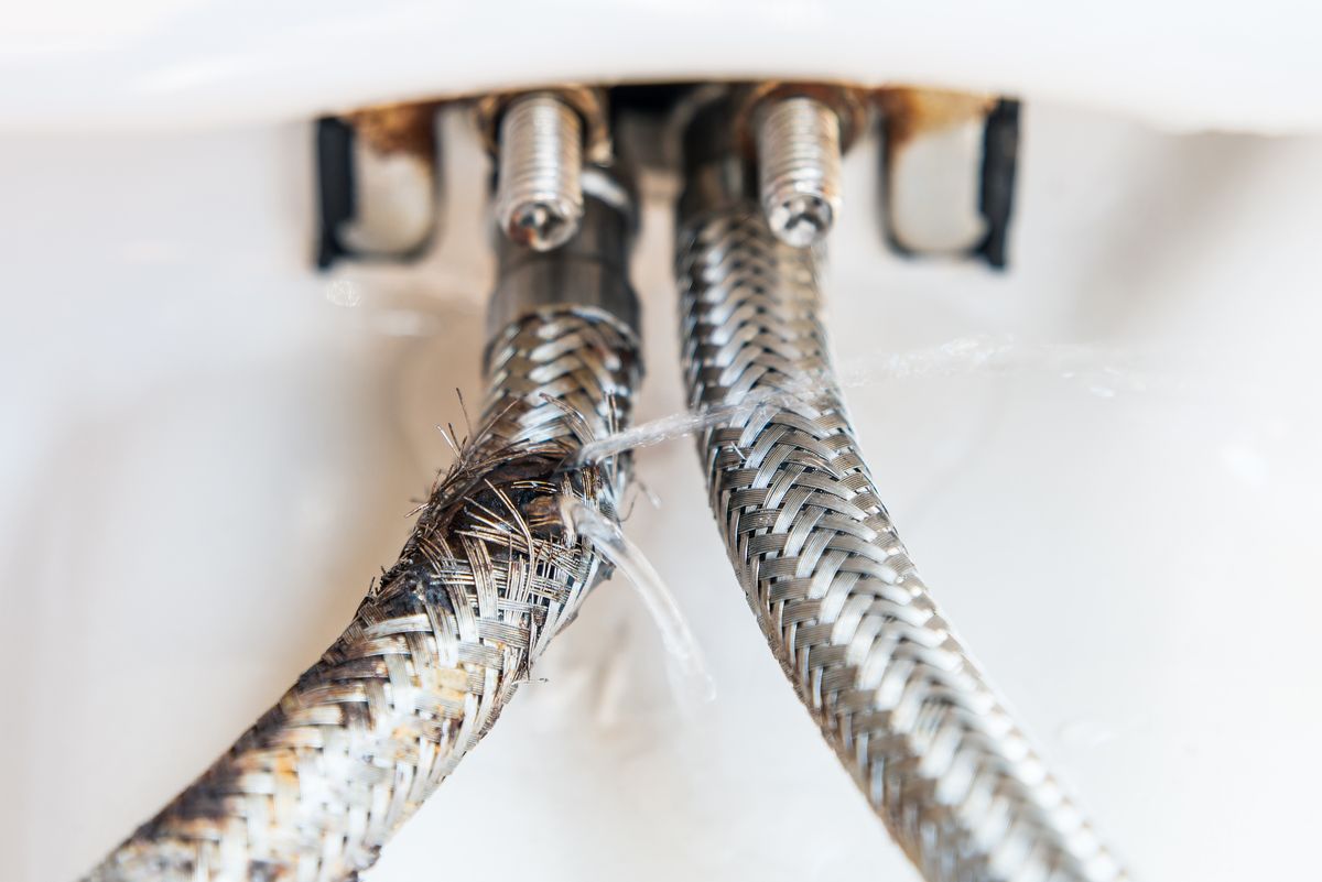 Close-up of deteriorating braided flexi hose with frayed stainless steel braiding
